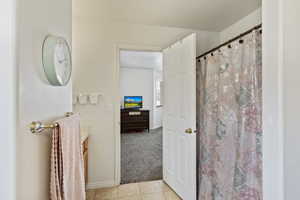 Bathroom with tile patterned floors, vanity, baseboards, and a shower with curtain
