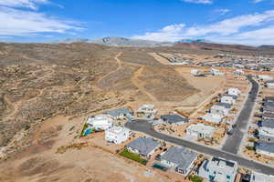 Aerial view of property and surrounding area with a mountainous background, a desert landscape, and nearby suburban area