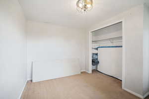 Unfurnished bedroom with baseboards, a closet, and carpet