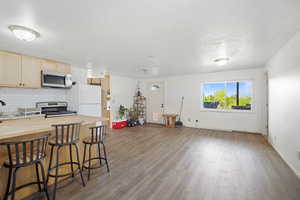Kitchen with wooden counters, stainless steel appliances, wood finished floors, and a kitchen breakfast bar