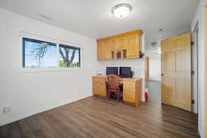 Office with baseboards, visible vents, and dark wood-style floors