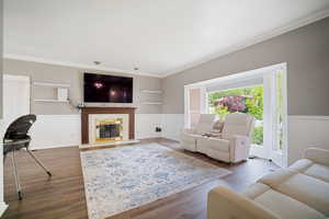 Living area with ornamental molding, a high end fireplace, dark wood-style floors, and built in shelves