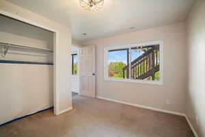 Unfurnished bedroom with a closet, a textured ceiling, baseboards, visible vents, and carpet floors
