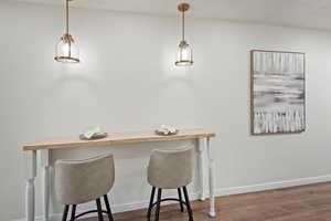 Dining area featuring wood finished floors and counter bar.