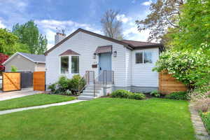 Bungalow featuring a gate, a chimney, and roof with shingles