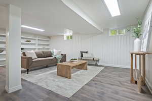 Great room area featuring wood like floors and built in shelving