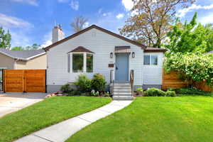 Bungalow-style house with a gate and a chimney