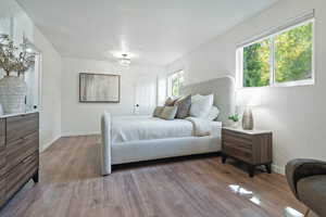 Primary Bedroom with wood finished floors and baseboards