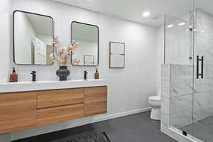 Primary Bathroom with over-sized shower,  toilet, double vanity, and recessed lighting