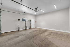 Garage with baseboards and a garage door opener