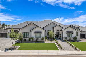 View of front of home featuring board and batten siding, stone siding, a tile roof, and driveway