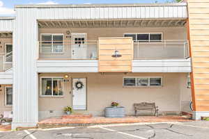 View of condo unit with included bench and flower bed.