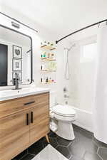 Full bathroom featuring toilet, vanity, tile patterned floors, and shower / bathtub combination with curtain