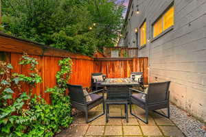 View of patio featuring an outdoor fire pit and fence