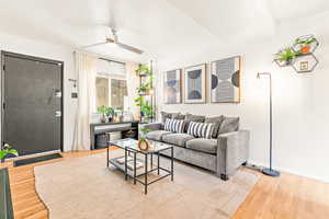 Living area featuring a ceiling fan and hardwood flooring
