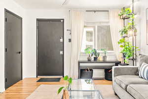 Entry door to living space with wood finished floors