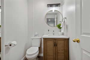 Bathroom with vanity, baseboards, and toilet