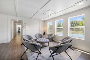 Living room with wood finished floors, baseboards, coffered ceiling, beamed ceiling, and recessed lighting