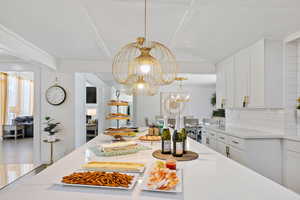 Dining area with a chandelier and beamed ceiling
