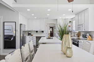 Kitchen featuring appliances with stainless steel finishes, recessed lighting, white cabinets, and light countertops