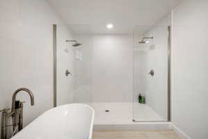 Full bath featuring a walk in shower, a freestanding bath, and recessed lighting