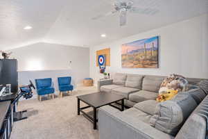 Carpeted living room with recessed lighting, ceiling fan, vaulted ceiling, and baseboards
