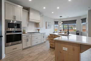 Kitchen featuring appliances with stainless steel finishes, a sink, recessed lighting, tasteful backsplash, and light wood finished floors