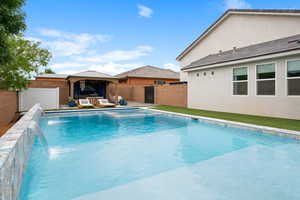 View of swimming pool featuring a gazebo, a fenced backyard, and a pool with connected hot tub