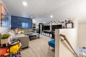 Living area featuring vaulted ceiling, carpet, a ceiling fan, and recessed lighting