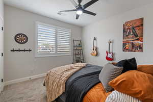 Carpeted bedroom with baseboards and a ceiling fan