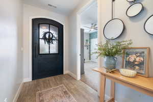 Foyer entrance with baseboards, wood finished floors, and ceiling fan
