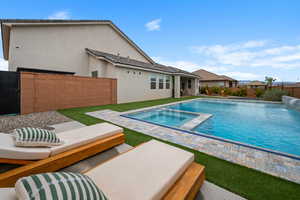View of swimming pool featuring an in-ground hot tub and fence