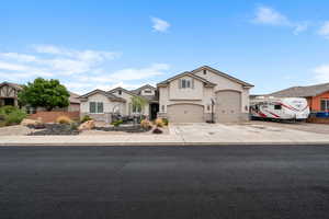 Traditional home with stucco siding, stone siding, concrete driveway, and fence
