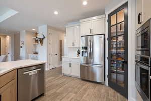 Kitchen with appliances with stainless steel finishes, light countertops, light wood-style floors, backsplash, and recessed lighting
