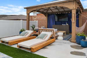 View of patio with a gazebo and fence