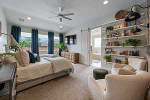 Bedroom with multiple windows, light colored carpet, a barn door, recessed lighting, and lofted ceiling