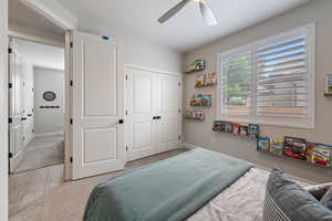Bedroom featuring a closet, carpet floors, a ceiling fan, and baseboards