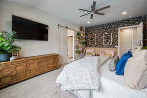 Bedroom featuring a barn door, wallpapered walls, recessed lighting, carpet flooring, and ceiling fan