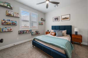 Carpeted bedroom featuring baseboards and ceiling fan