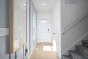 Entryway with stairs, light wood-style floors, and recessed lighting