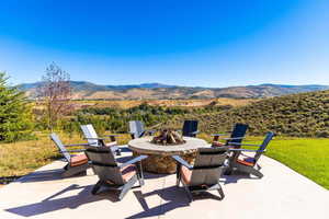 View of patio with an outdoor fire pit and a mountain view