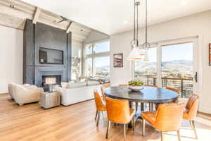 Dining space featuring light wood-style flooring, a fireplace, and lofted ceiling