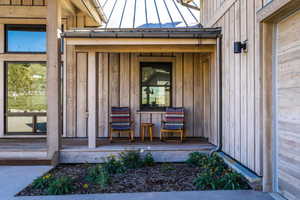 Doorway to property featuring board and batten siding and a standing seam roof
