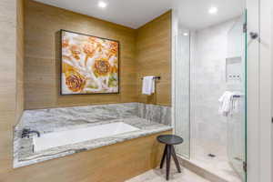 Bathroom featuring a stall shower, a garden tub, and recessed lighting