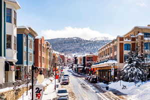 View of asphalt street featuring a mountain view, street lights, and sidewalks