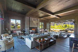 Living room featuring wood walls, wood ceiling, beamed ceiling, wood-type flooring, and coffered ceiling
