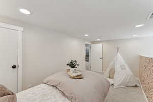 Bedroom featuring carpet flooring, a closet, visible vents, and recessed lighting