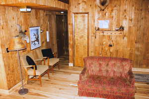 Living area featuring wooden walls and hardwood / wood-style floors