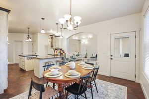 Dining area with an inviting chandelier, a wealth of natural light, and arched walkways