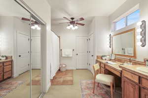 Primary bathroom with a shower with curtain, vanity, and ceiling fan